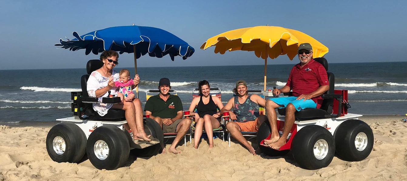 Renting two powered beach wheelchairs on sand with family in Ocean City, MD